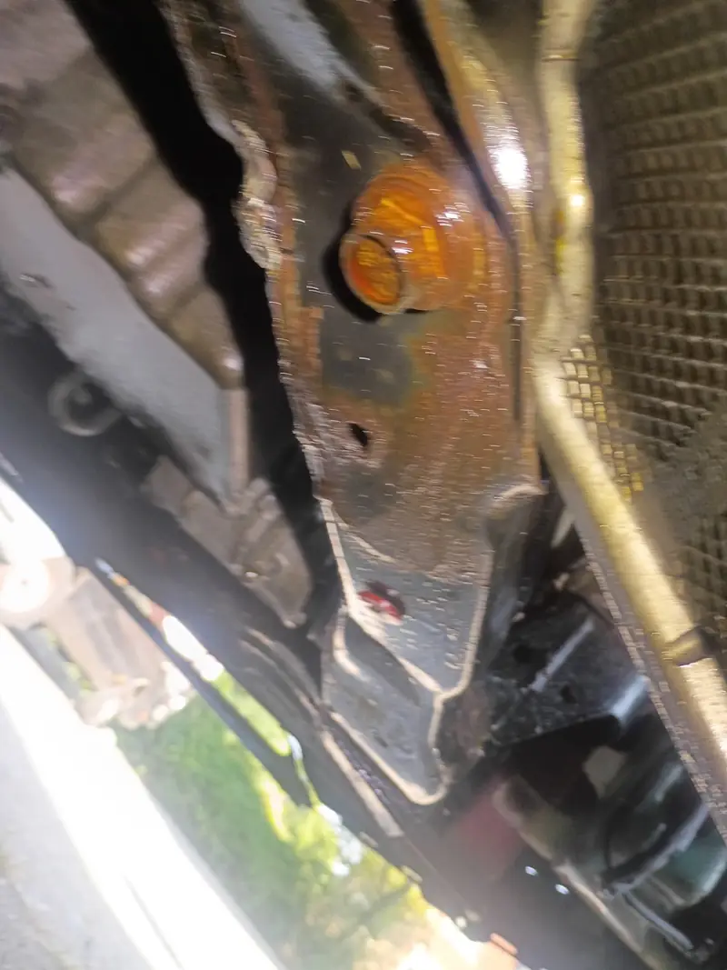 Underbody pinch weld jack point and factory jack pad on a vehicle frame rail seen from below