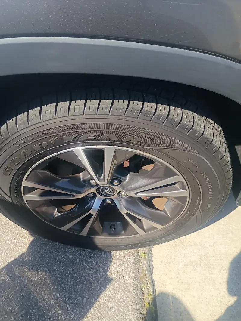 Freshly mounted Goodyear Assurance 245/60R18 tire on a Toyota alloy wheel after a mobile tire replacement