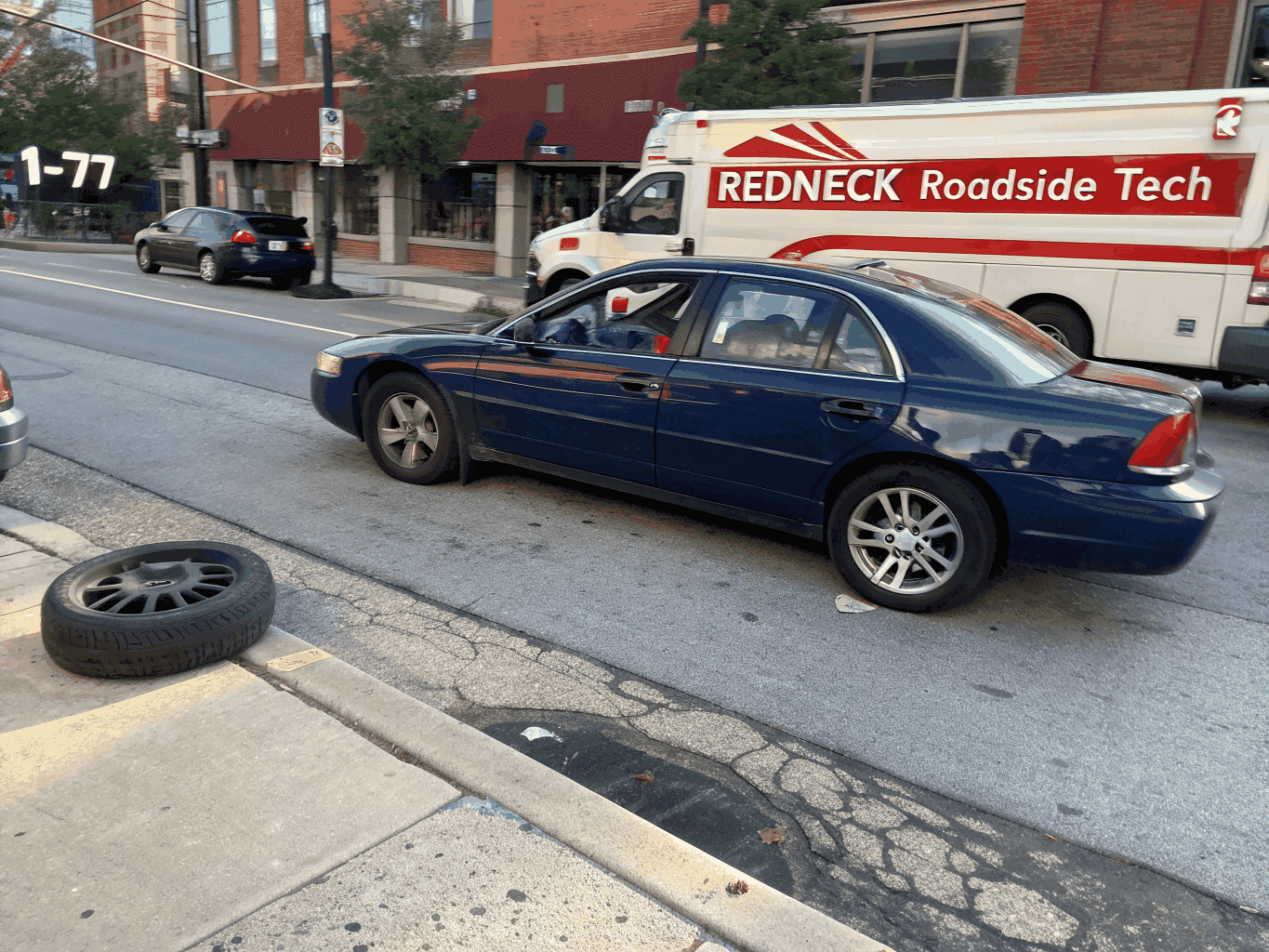 Redneck Roadside Tech service vehicle assisting a stranded driver on a busy Cincinnati expressway