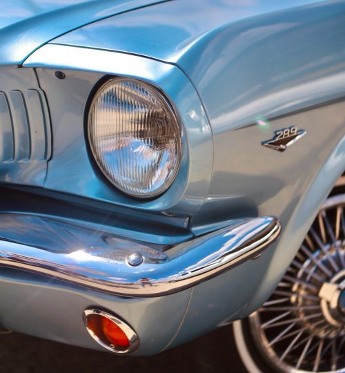 Vintage blue Ford Mustang showcasing chrome trims and headlight details.